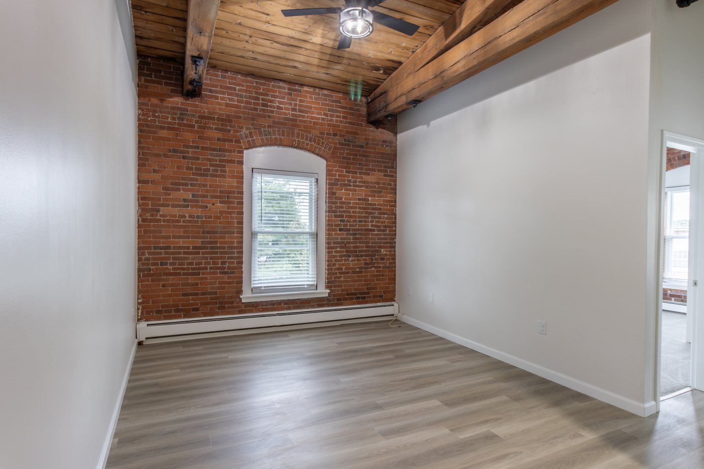 Renovated apartment with exposed brick and wood beam ceiling